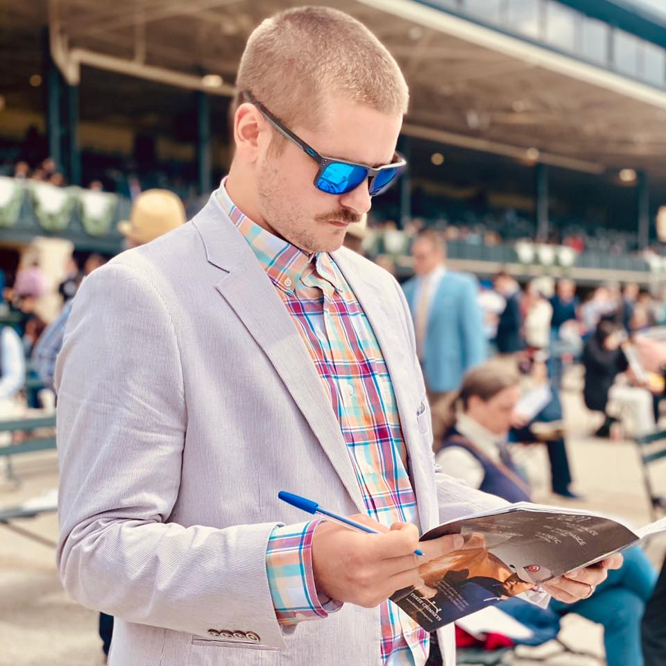 Male looking at betting book at horse race