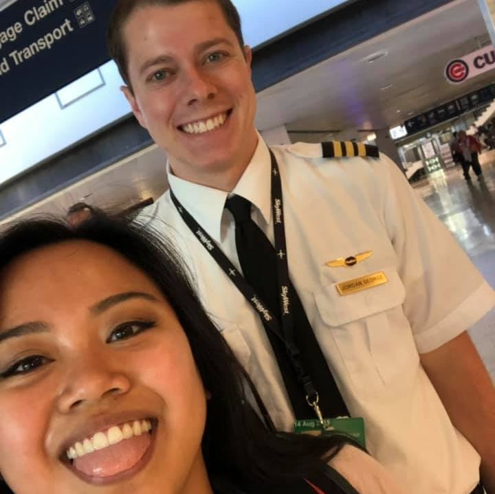 Male pilot and flight attendant smiling